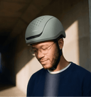 Person wearing a green headfirst Echo Pro helmet, standing against a neutral background