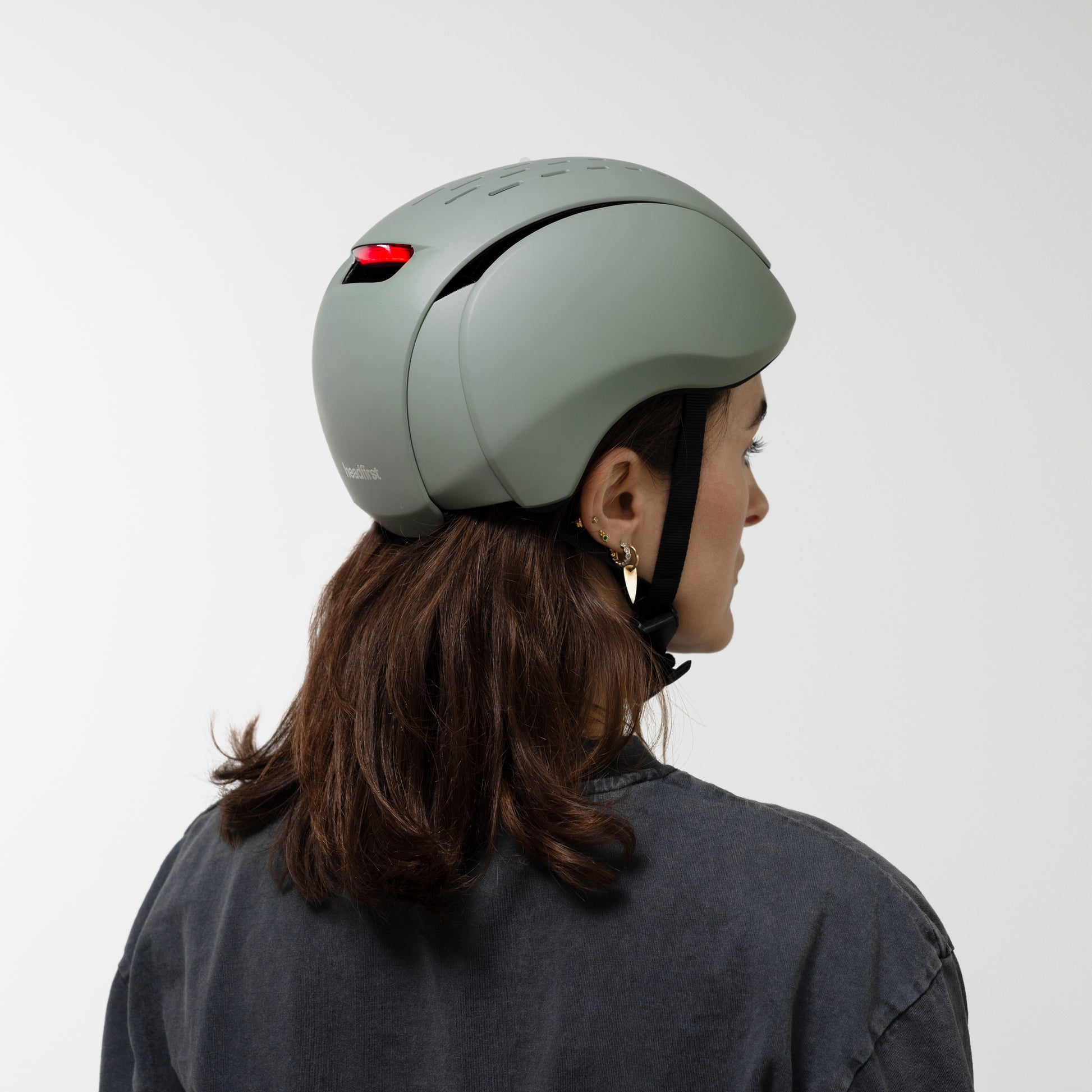 Person wearing a green helmet on a plain background. headfirst helmets Echo Pro matt green Laura 